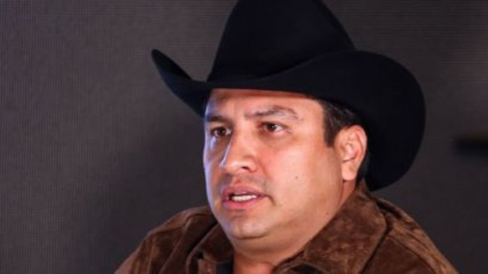 Julión Álvarez pisa y rompe el celular que le lanzaron al escenario