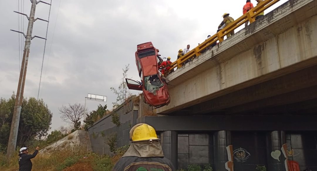 Auto queda colgando de un puente en el Periférico Ecológico; bomberos realizan rescate